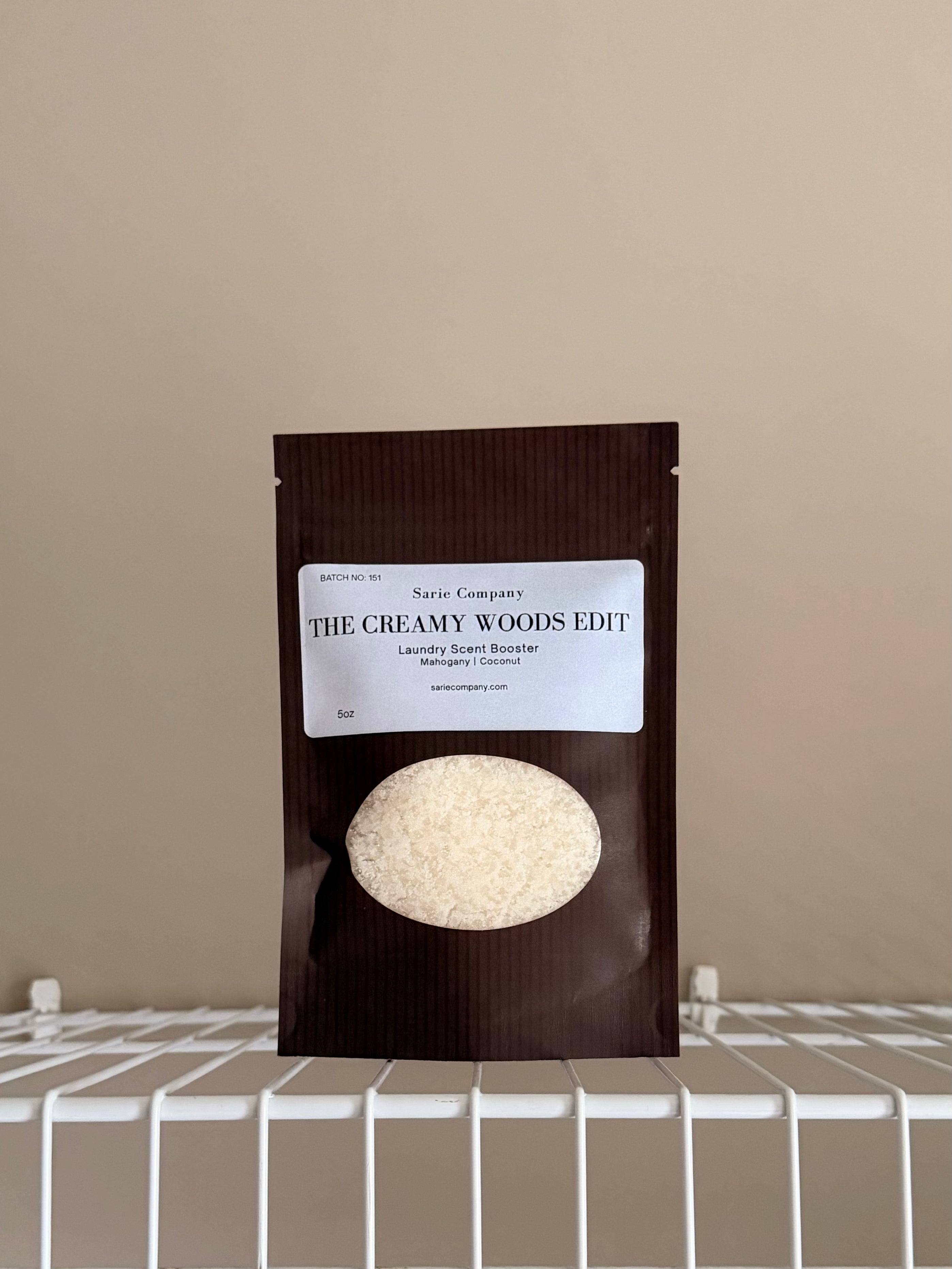 The Creamy Woods Edit sampler pouch on a beige background with a white shelf.