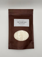 Brown packaging of 'The Noir Edit' with a white label on a white background