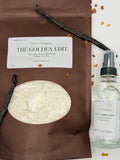A room spray and laundry scent booster from Sarie Company's Golden Edit displayed with vanilla beans, and amber crystals on a white surface.