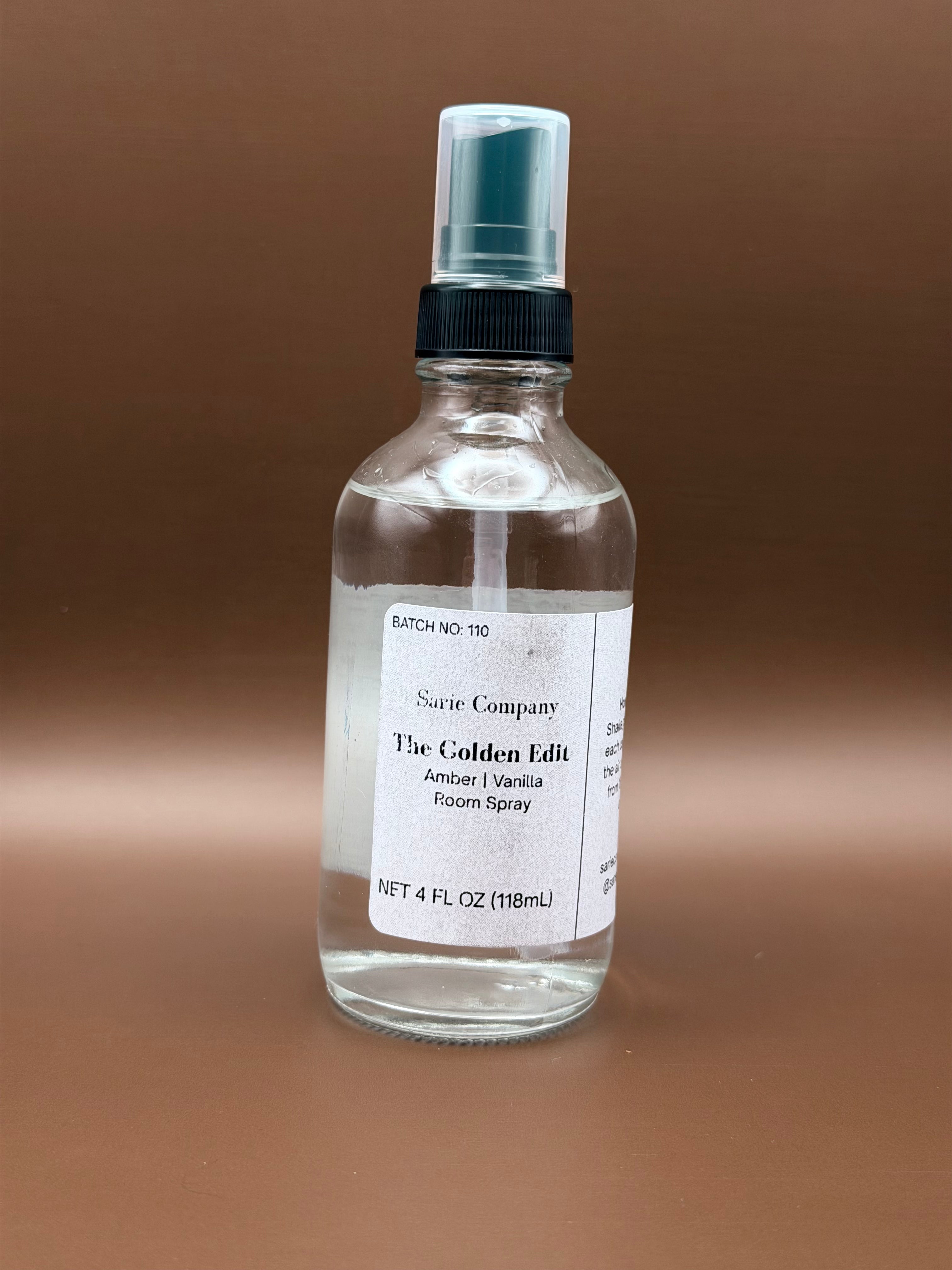 Clear spray bottle with a label on a brown background