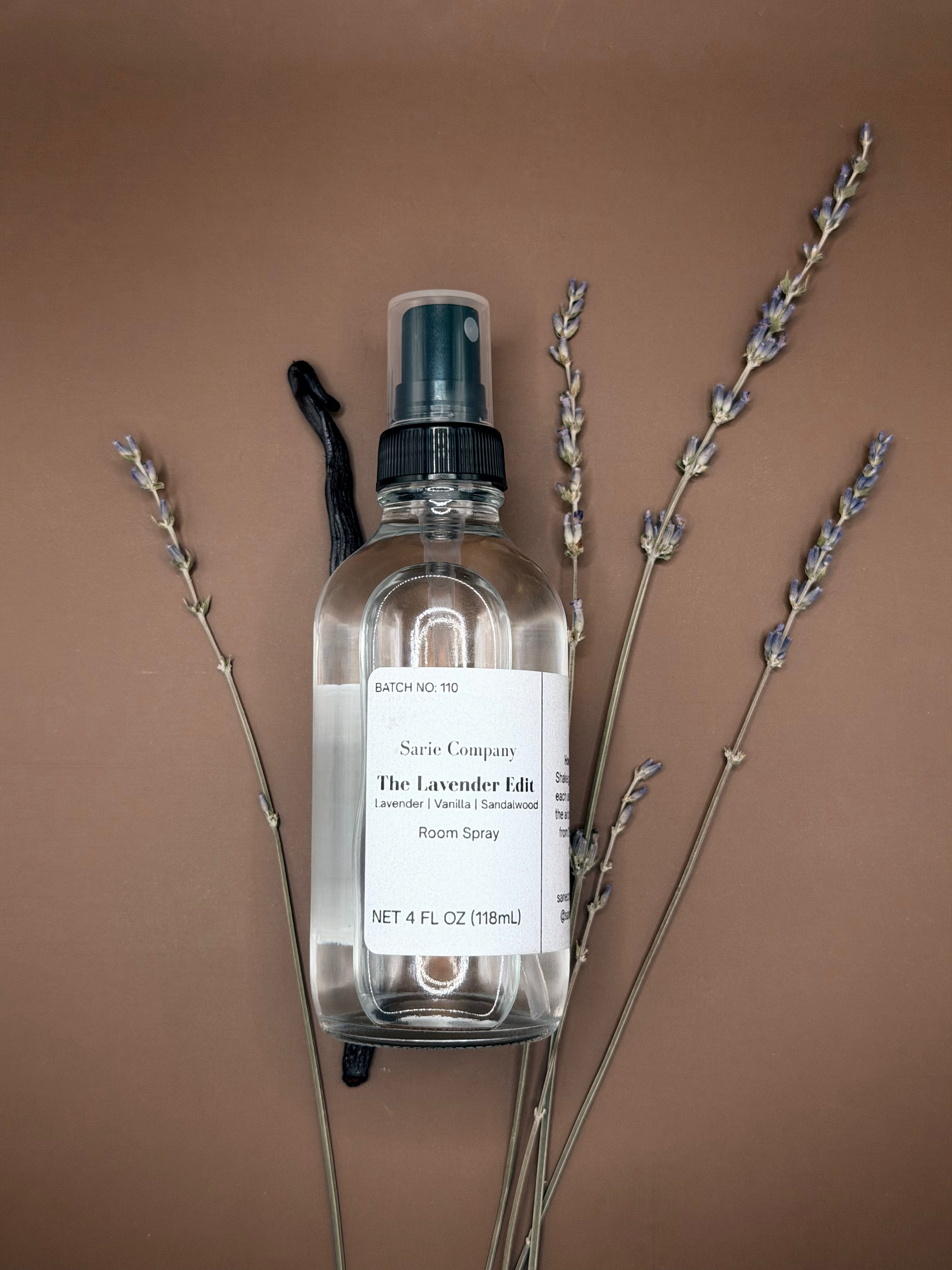 Clear spray bottle with lavender on a brown background