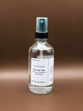Clear spray bottle with a label on a brown background