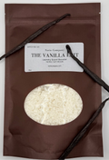 Brown package of Sarie Company's Vanilla Edit scent booster on a white background with vanilla beans.