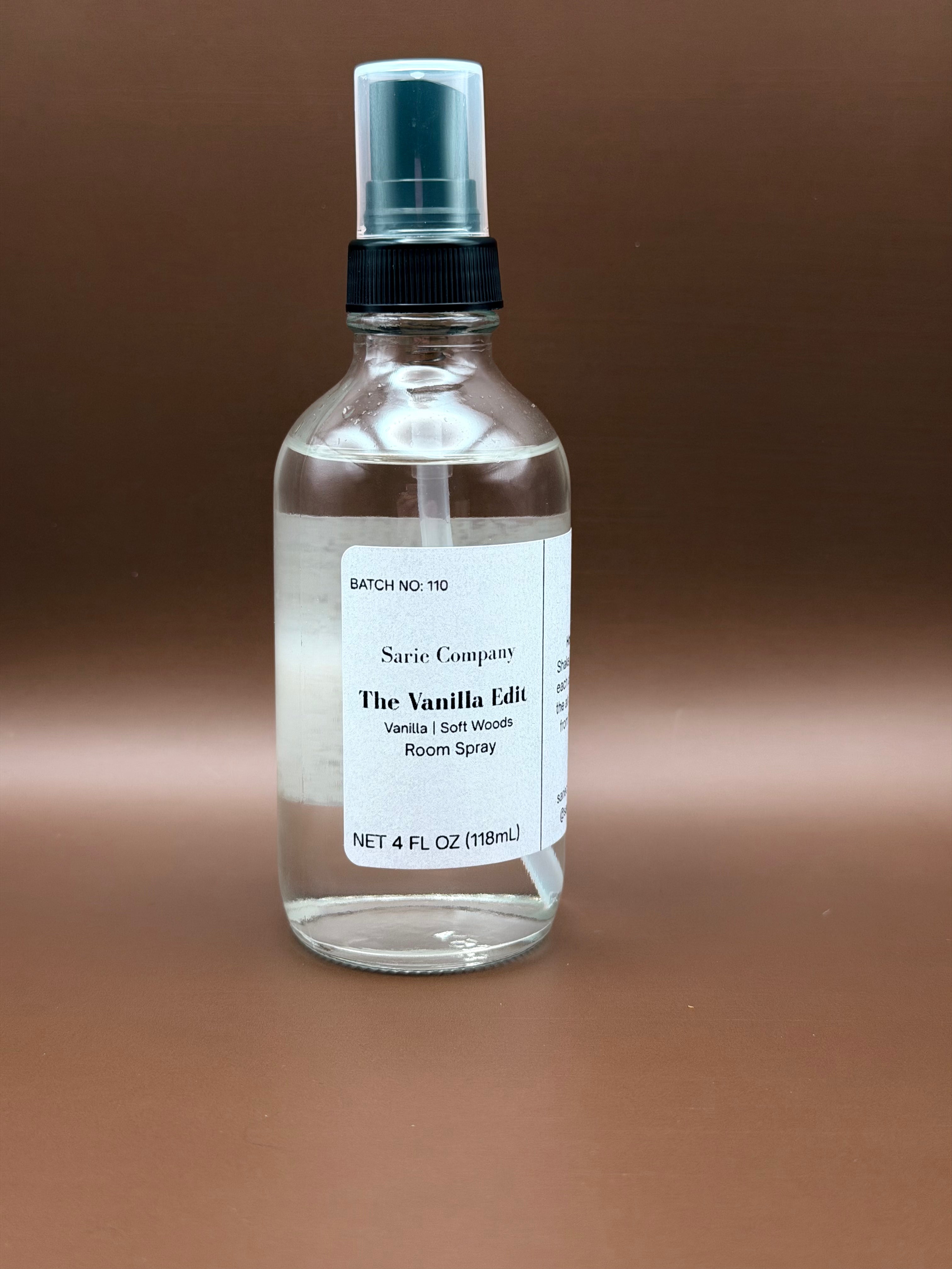 Clear room spray bottle with a label on a brown background