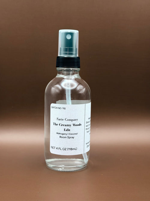 Clear glass spray bottle with a label on a brown background
